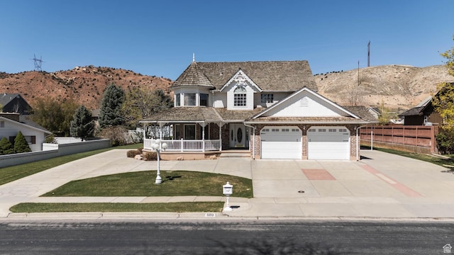 889 Upland Dr, Richfield, UT 84701 - victorian home with a porch, a garage, brick siding, concrete driveway, and fence