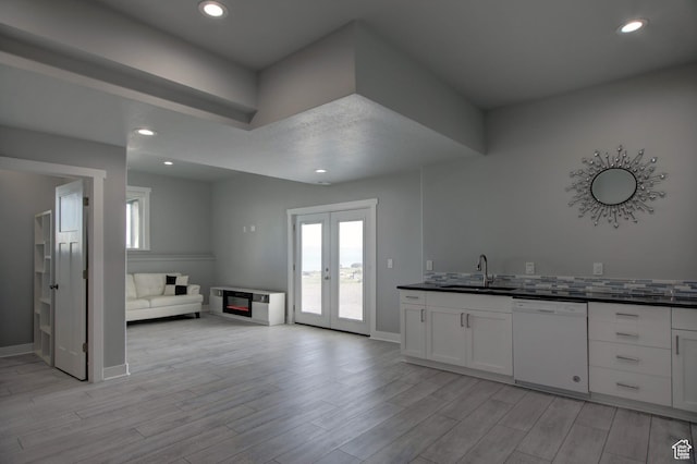 728 Loveland Ln, Fish Haven, ID 83287 - kitchen with white dishwasher, dark countertops, light wood finished floors, a sink, and open floor plan