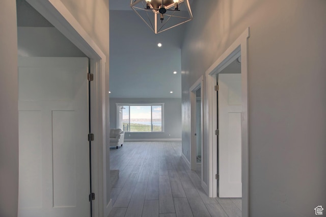 728 Loveland Ln, Fish Haven, ID 83287 - corridor featuring baseboards, wood finished floors, and a notable chandelier