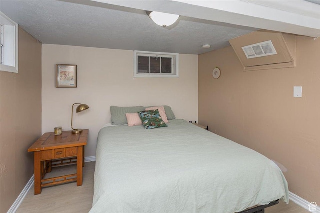 bedroom with baseboards, visible vents, and light wood-style floors
