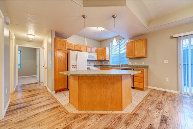 170 W Albion Village Way Unit 202, Sandy, UT 84070 - kitchen featuring white appliances, light wood-style flooring, a kitchen island, pendant lighting, and baseboards