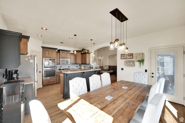 302 Old Farm Rd, Erda, UT 84074 - dining area with light wood-type flooring, arched walkways, and recessed lighting