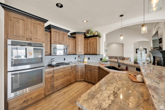 302 Old Farm Rd, Erda, UT 84074 - kitchen with stainless steel appliances, backsplash, arched walkways, and a sink