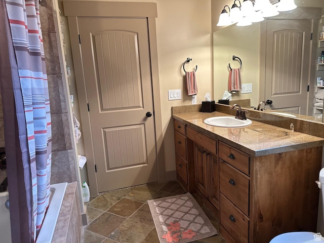 620 W Cisco Run Run, Garden City, UT 84028 - bathroom with stone finish flooring, a notable chandelier, tiled shower / bath combo, and vanity