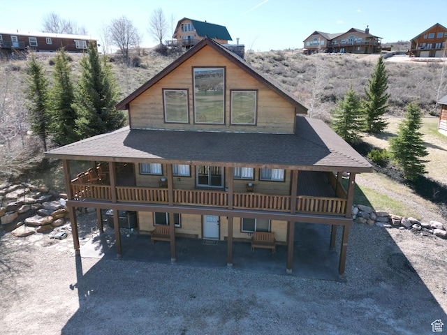 rear view of property with a patio area, a shingled roof, and a wooden deck
