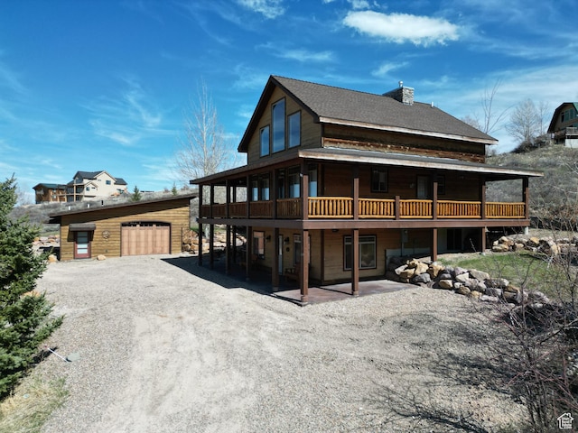 620 W Cisco Run Run, Garden City, UT 84028 - back of house featuring a chimney, an outdoor structure, a garage, dirt driveway, and a wooden deck