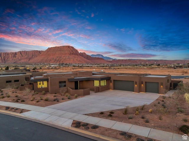 533 S Kwavasa Dr, Ivins, UT 84738 - pueblo-style house featuring a garage, a mountain view, stucco siding, and driveway