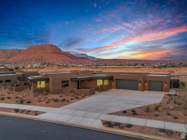 533 S Kwavasa Dr, Ivins, UT 84738 - pueblo-style home featuring an attached garage, a mountain view, driveway, and stucco siding