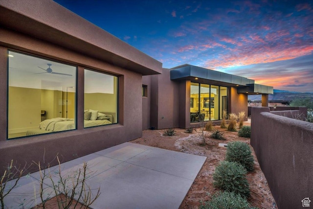 533 S Kwavasa Dr, Ivins, UT 84738 - back of house at dusk featuring stucco siding and a patio