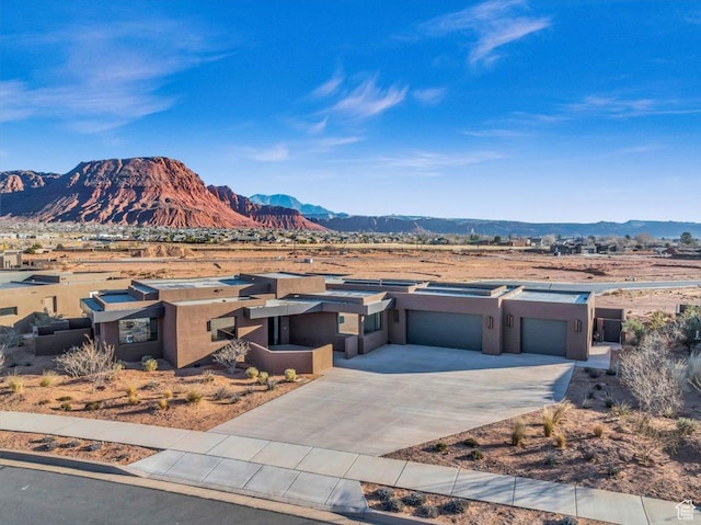 533 S Kwavasa Dr, Ivins, UT 84738 - view of front of home featuring stucco siding, concrete driveway, a mountain view, and a garage