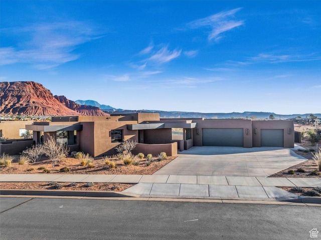 533 S Kwavasa Dr, Ivins, UT 84738 - view of front of property with a mountain view, stucco siding, driveway, and an attached garage