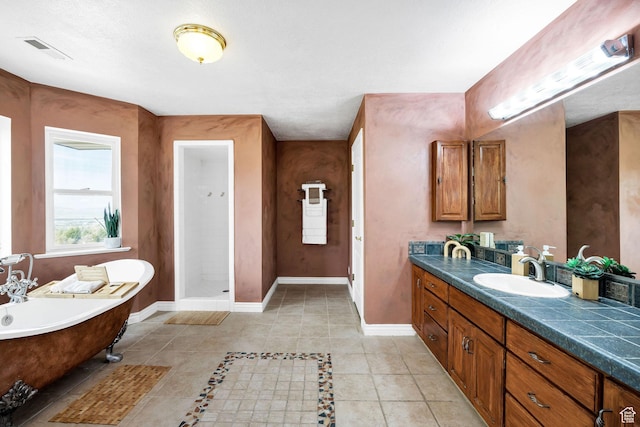 1910 E Canyon Ridge Dr, North Logan, UT 84341 - full bath with visible vents, baseboards, a freestanding tub, vanity, and tile patterned flooring
