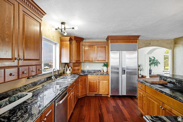1910 E Canyon Ridge Dr, North Logan, UT 84341 - kitchen featuring dark wood finished floors, plenty of natural light, appliances with stainless steel finishes, and brown cabinets