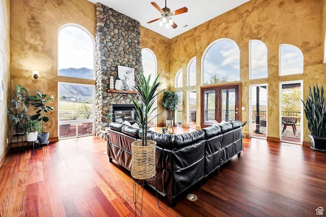 1910 E Canyon Ridge Dr, North Logan, UT 84341 - living area featuring french doors, a fireplace, a towering ceiling, wood finished floors, and a ceiling fan