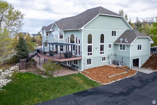 1910 E Canyon Ridge Dr, North Logan, UT 84341 - back of house featuring a yard, stairway, a shingled roof, a wooden deck, and an attached garage