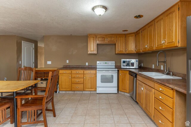 1910 E Canyon Ridge Dr, North Logan, UT 84341 - kitchen with brown cabinetry, a textured ceiling, a sink, and stainless steel appliances