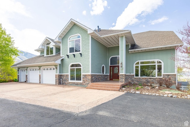 1910 E Canyon Ridge Dr, North Logan, UT 84341 - craftsman-style house with driveway, roof with shingles, and stone siding