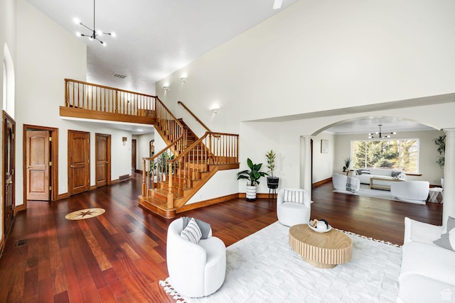 1910 E Canyon Ridge Dr, North Logan, UT 84341 - living area with a high ceiling, stairway, a notable chandelier, arched walkways, and wood finished floors