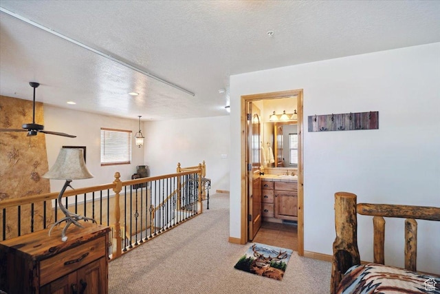 3634 N Huntsman Path Unit C201, Eden, UT 84310 - hallway with a textured ceiling, a sink, an upstairs landing, baseboards, and light carpet