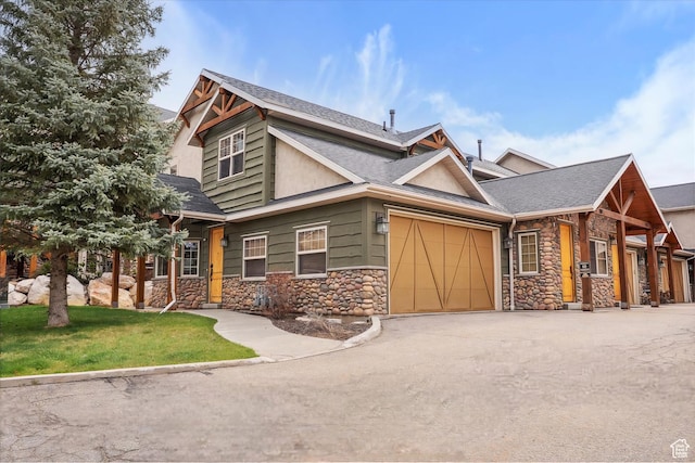 craftsman inspired home with driveway, stone siding, an attached garage, and roof with shingles