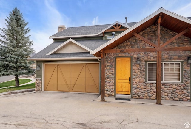 3634 N Huntsman Path Unit C201, Eden, UT 84310 - view of front of home with driveway, a garage, a chimney, and stone siding