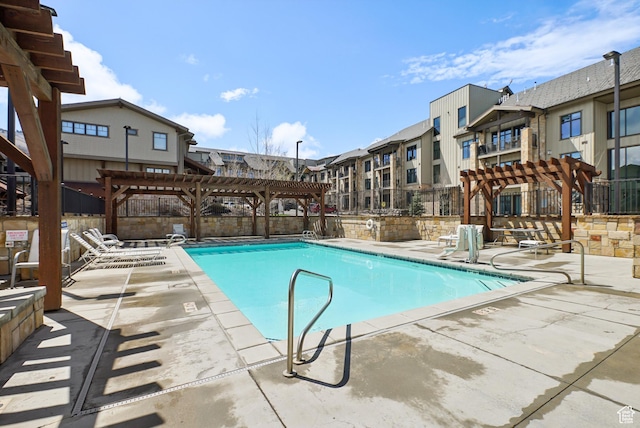 community pool featuring a residential view, a pergola, a patio, and fence