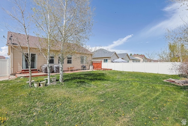 5454 N Windsor Way E, Stansbury Park, UT 84074 - back of property with a fenced backyard and a patio