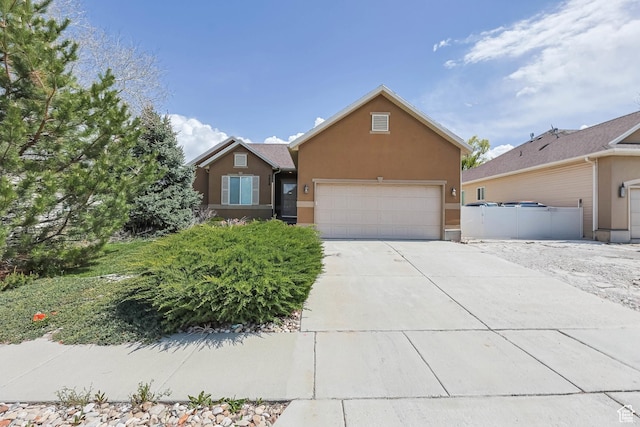 view of front of house with stucco siding, concrete driveway, and an attached garage