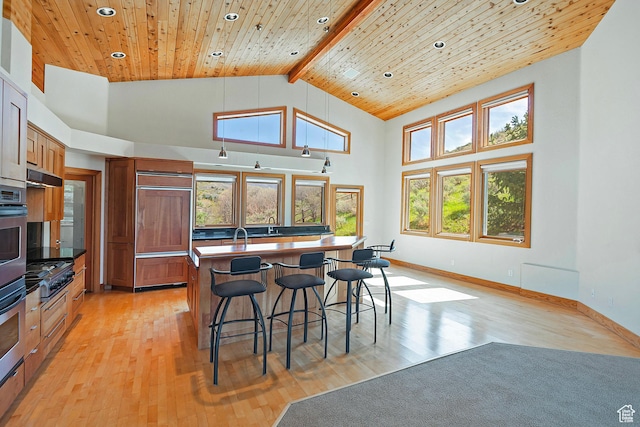152 N Silver Oak Rd, Salt Lake City, UT 84108 - kitchen with paneled fridge, a kitchen bar, recessed lighting, light wood finished floors, and high vaulted ceiling