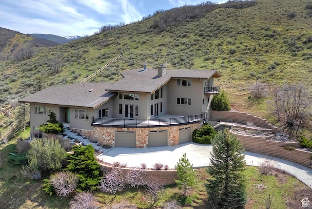 152 N Silver Oak Rd, Salt Lake City, UT 84108 - rear view of house with a mountain view, a balcony, driveway, and an attached garage
