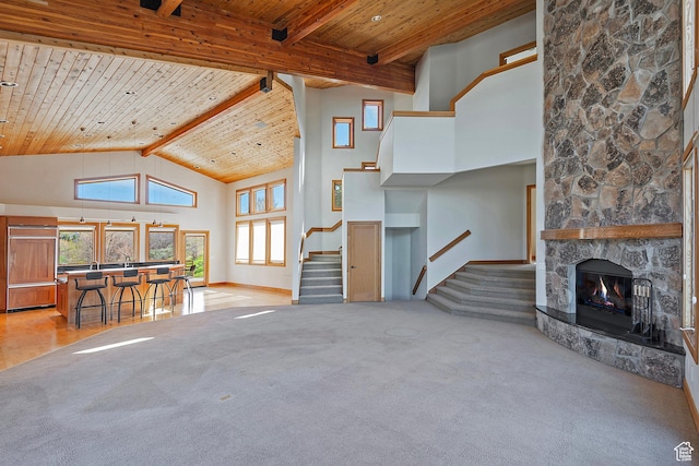 152 N Silver Oak Rd, Salt Lake City, UT 84108 - living area with wood ceiling, beamed ceiling, light colored carpet, a stone fireplace, and stairs