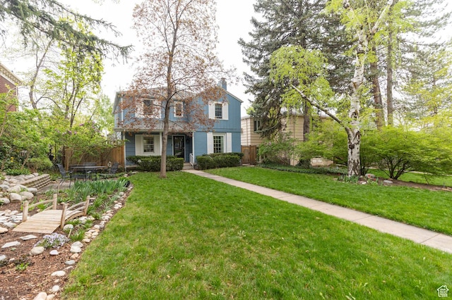traditional-style house featuring a chimney and a front lawn