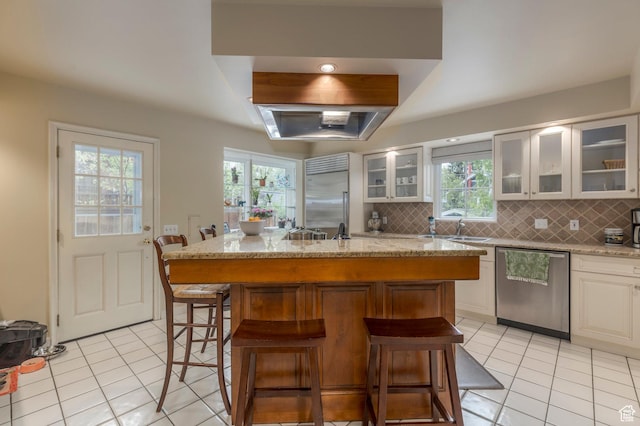 1280 E 3rd Ave N, Salt Lake City, UT 84103 - kitchen featuring tasteful backsplash, a breakfast bar area, light tile patterned floors, stainless steel appliances, and a sink
