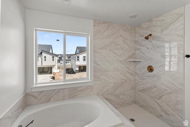 bathroom featuring a garden tub and tiled shower
