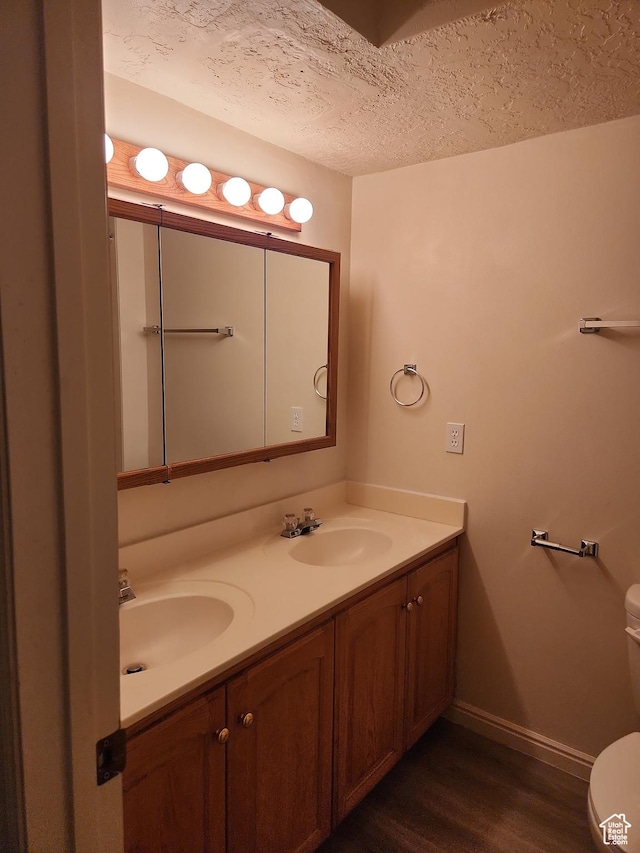1514 S 200 E, Orem, UT 84058 - bathroom featuring a textured ceiling, a sink, double vanity, baseboards, and wood finished floors