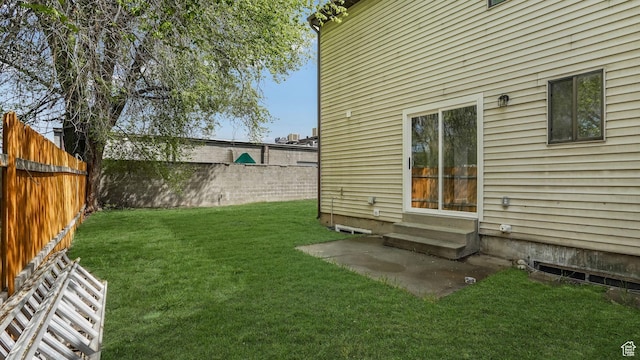 view of yard featuring entry steps and a fenced backyard