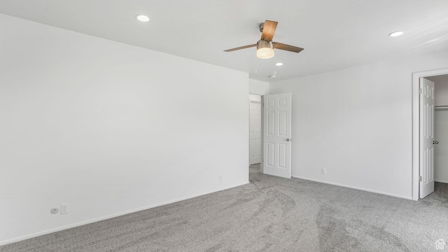 unfurnished bedroom with carpet, a spacious closet, and recessed lighting