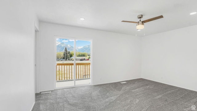 carpeted spare room with recessed lighting, a ceiling fan, a mountain view, and baseboards