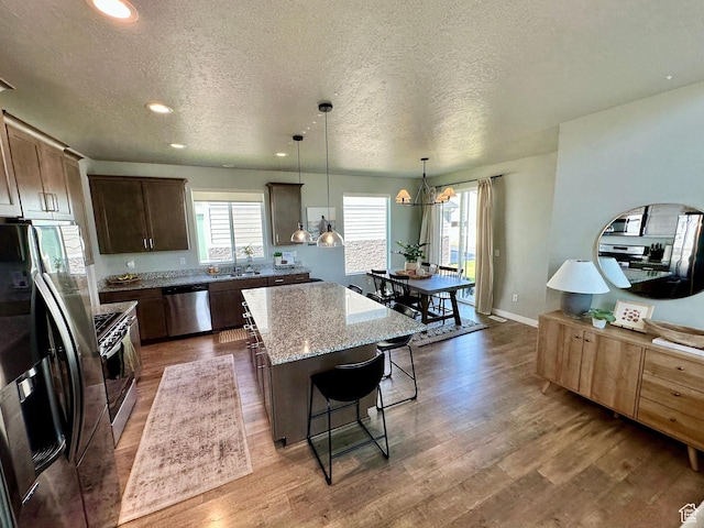 980 W 1275 S, Springville, UT 84663 - kitchen featuring stainless steel appliances, a textured ceiling, wood finished floors, and a kitchen island