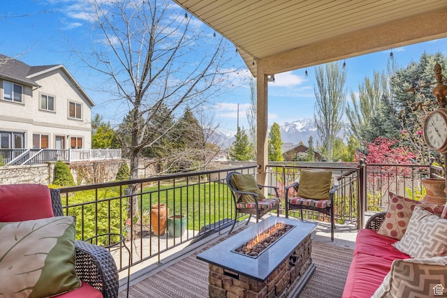 wooden terrace with an outdoor living space with a fire pit and a yard
