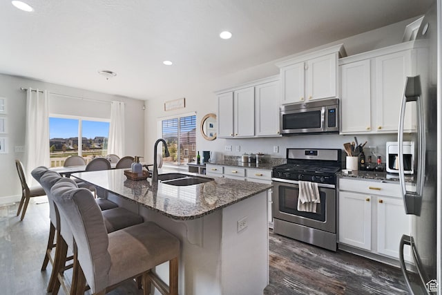 6463 W Maple Valley Cir S Unit 1030, West Jordan, UT 84081 - kitchen with dark stone countertops, recessed lighting, a kitchen island with sink, appliances with stainless steel finishes, and a sink