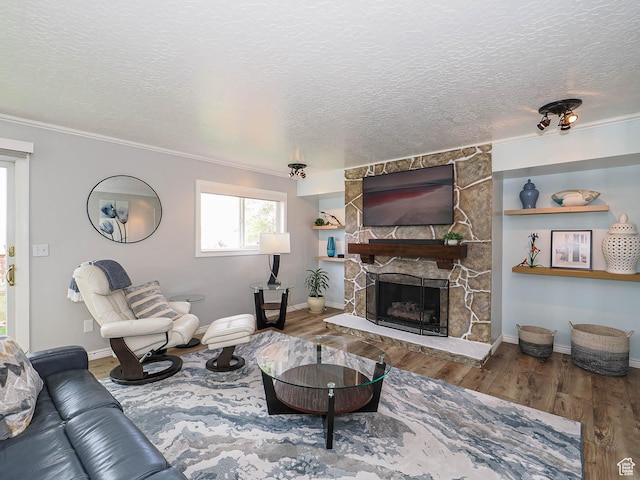 123 Lynnwood Dr, Clearfield, UT 84015 - living room featuring crown molding, a textured ceiling, a stone fireplace, and wood finished floors