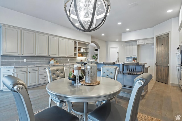 11274 S Eagle View Dr, Sandy, UT 84092 - dining room with recessed lighting, arched walkways, a notable chandelier, and light wood-type flooring