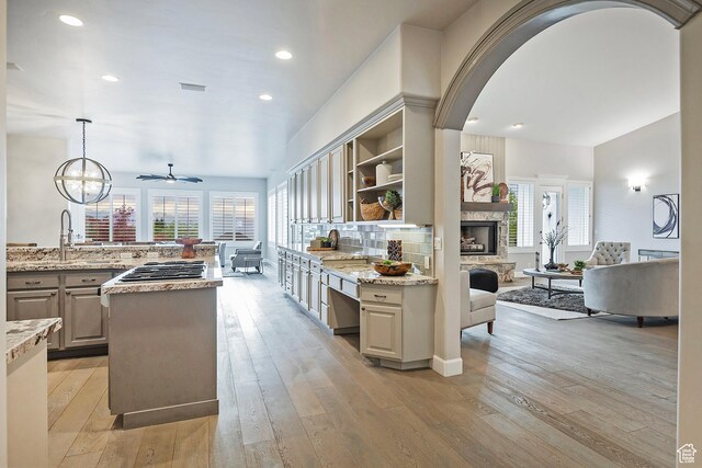 11274 S Eagle View Dr, Sandy, UT 84092 - kitchen featuring open shelves, arched walkways, open floor plan, light wood-type flooring, and a ceiling fan