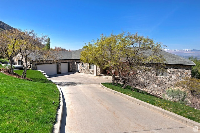 11274 S Eagle View Dr, Sandy, UT 84092 - view of front of house with concrete driveway, stone siding, a front yard, a mountain view, and an attached garage