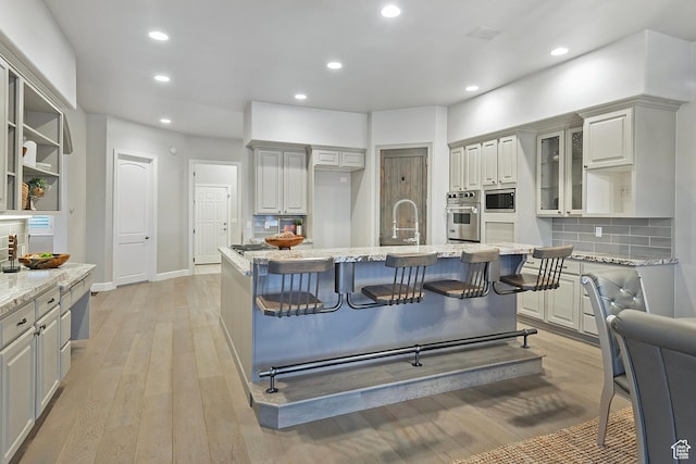 11274 S Eagle View Dr, Sandy, UT 84092 - kitchen featuring tasteful backsplash, light wood-style floors, stainless steel appliances, light stone countertops, and recessed lighting