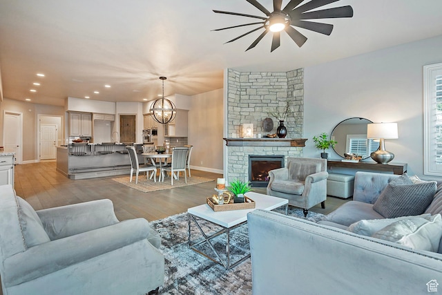 11274 S Eagle View Dr, Sandy, UT 84092 - living area featuring recessed lighting, a fireplace, light wood-type flooring, baseboards, and ceiling fan with notable chandelier