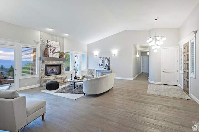 11274 S Eagle View Dr, Sandy, UT 84092 - living room featuring lofted ceiling, baseboards, a fireplace, wood finished floors, and a notable chandelier