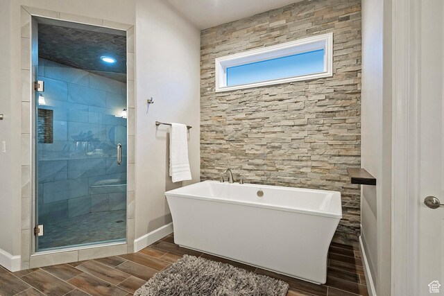 11274 S Eagle View Dr, Sandy, UT 84092 - full bathroom featuring wood finish floors, a freestanding bath, a shower stall, and baseboards