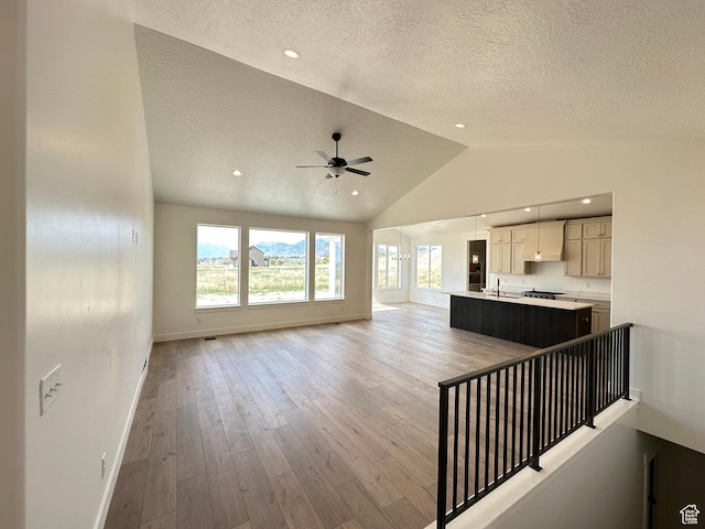 287 E 1150 N Unit 73, Salem, UT 84653 - unfurnished living room featuring a textured ceiling, lofted ceiling, ceiling fan, and light wood-type flooring